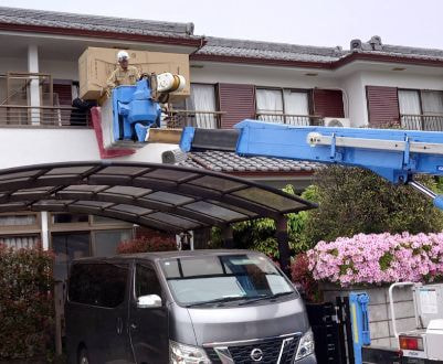 クレーンで冷蔵庫を2階へ搬入している様子